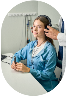 A woman wearing headphones showcasing what happens during adult hearing tests