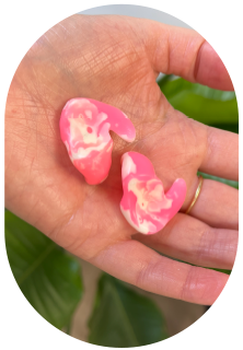 Our audiologist holding pink custom ear plugs in Markham, Ontario