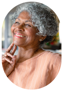 An older woman smiling as she gets ready for the mobile hearing clinic to provide an in-home hearing test