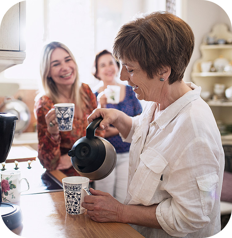 Women drinking coffee as the mobile hearing clinic visits her at home